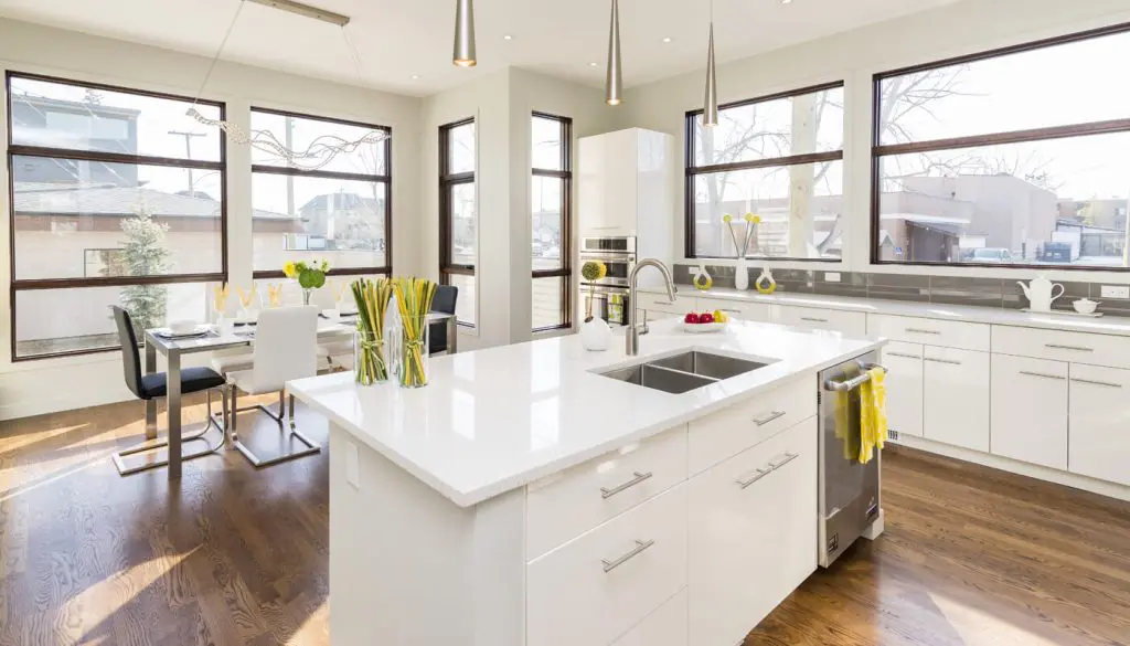 Modern white kitchen with large windows.