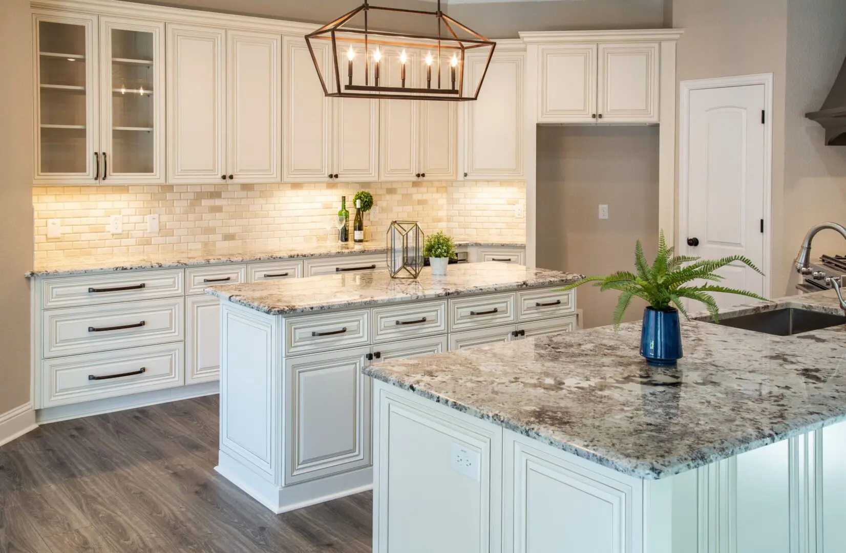 Elegant kitchen with granite island and chandelier.