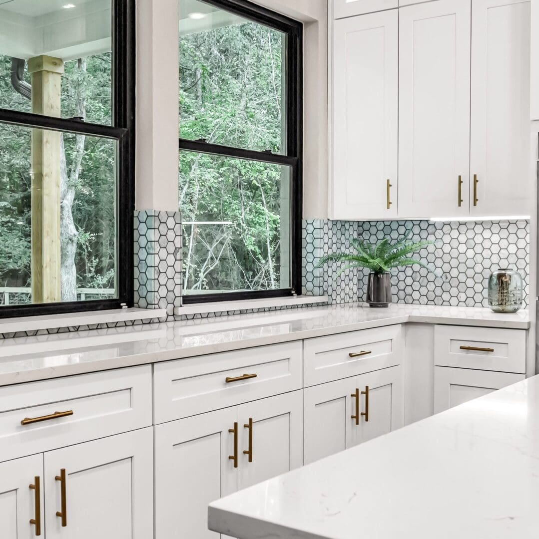 White kitchen with window and gold hardware.