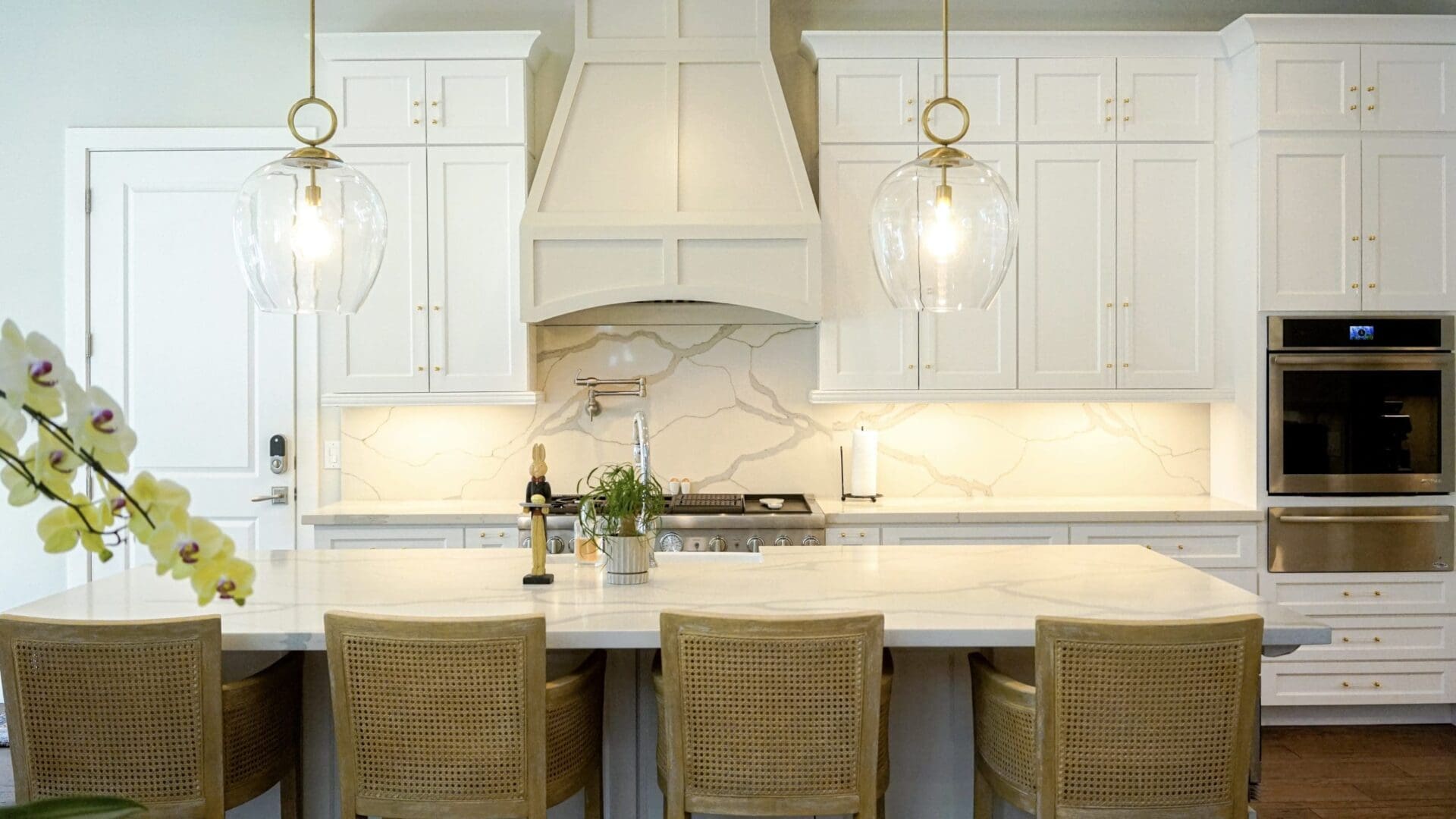 Bright kitchen with marble island and chairs.