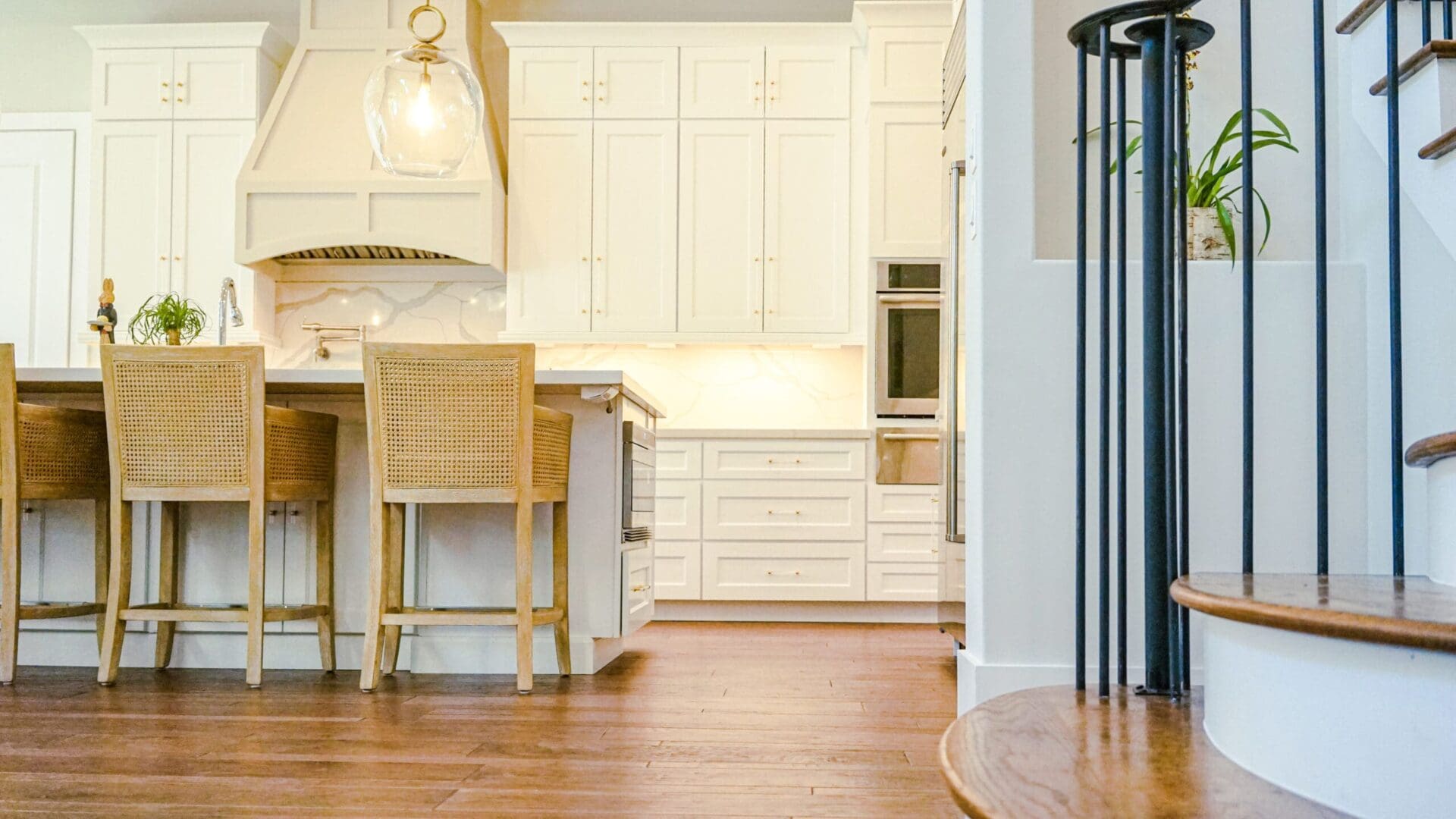 Bright kitchen with island and stairs.